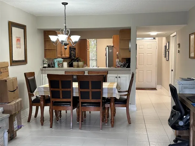 a view of a refrigerator in kitchen and an empty room