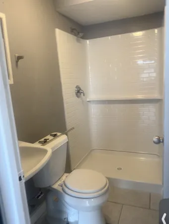 a white toilet sitting next to a bath tub