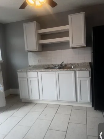 a kitchen with granite countertop white cabinets and stainless steel appliances