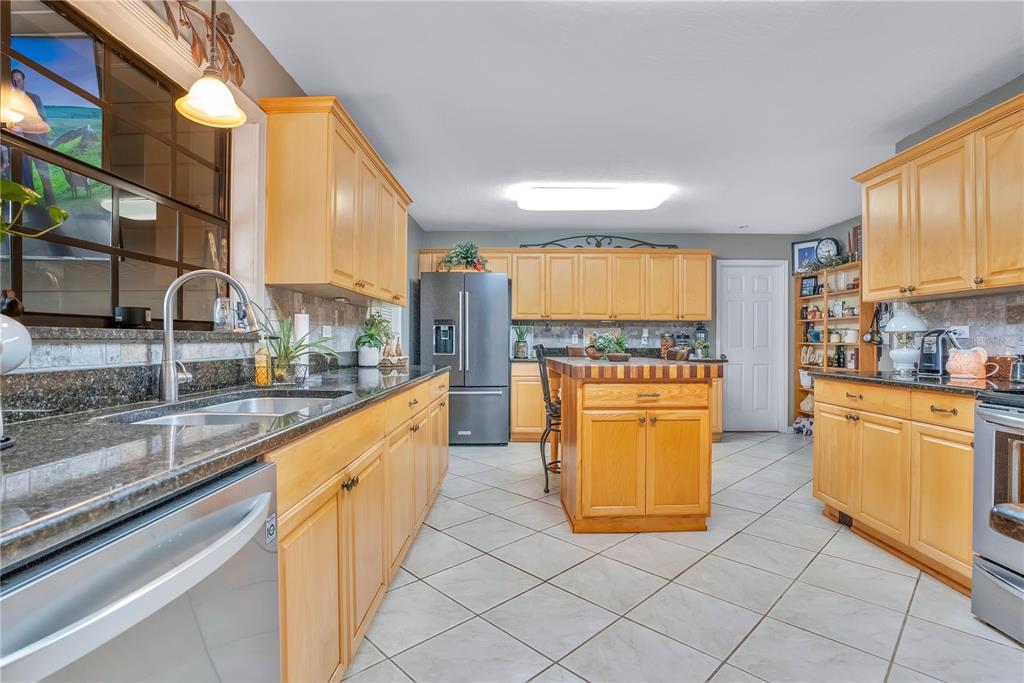 2067 Lake Juanita Road Seville, FL 32190 - Photo 12 of 96 a large kitchen with stainless steel appliances granite countertop a large counter top and a stove
