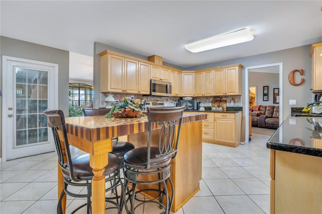 2067 Lake Juanita Road Seville, FL 32190 - Photo 15 of 96 a dining hall with stainless steel appliances kitchen island granite countertop a dining table chairs and view living room