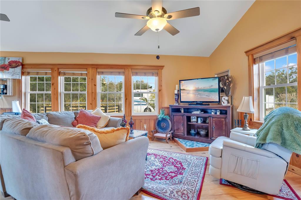 2067 Lake Juanita Road Seville, FL 32190 - Photo 52 of 96 a living room with furniture a floor to ceiling window and a flat screen tv