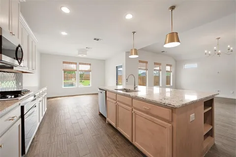 a kitchen with stainless steel appliances granite countertop a stove and a wooden floors