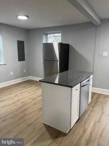 a kitchen with granite countertop a refrigerator and a sink