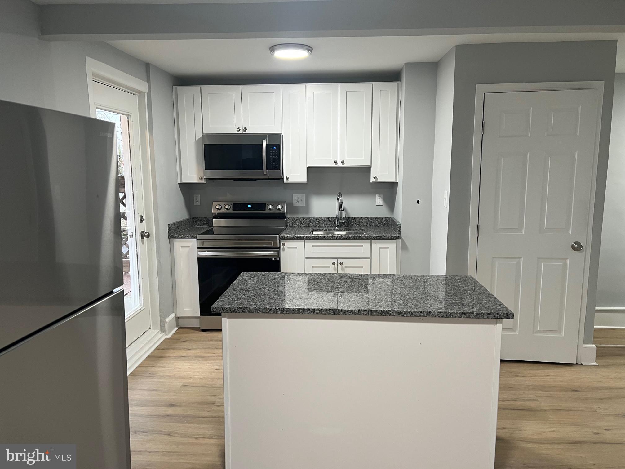 8511 Chestnut Oak Road Parkville, MD 21234 - Photo 7 of 17 a kitchen with granite countertop a refrigerator stove and microwave