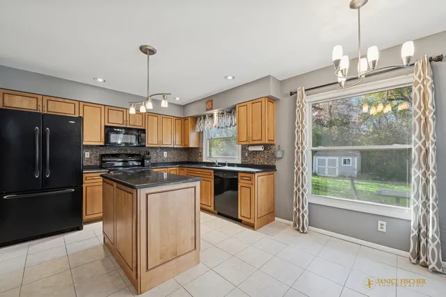 a kitchen with stainless steel appliances granite countertop a refrigerator and a stove top oven