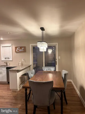 a view of a dining room with furniture wooden floor and a chandelier