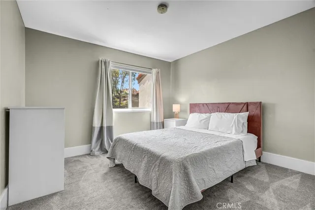 a bedroom with a bed and painting on the wall