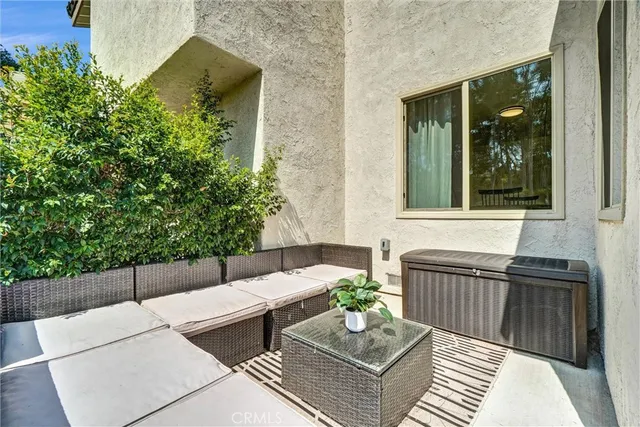 a view of a patio with couches table and chairs and potted plants
