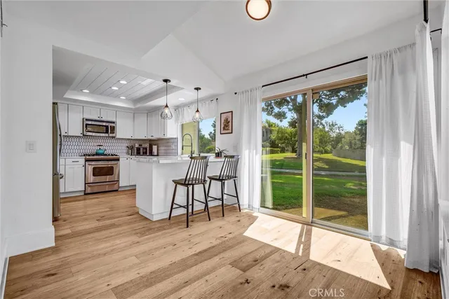 a view of a kitchen with dining space wooden floor and a window
