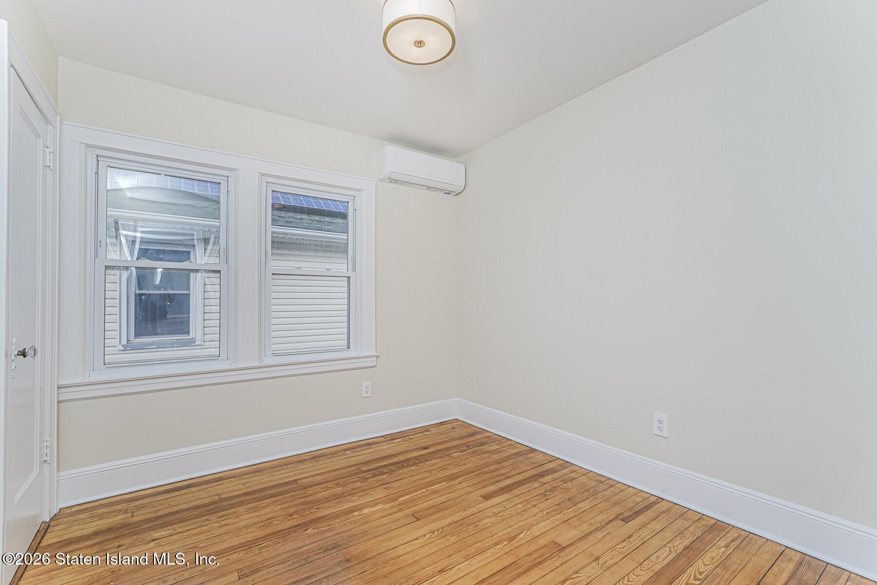 332 Willowbrook Road Staten Island, NY 10314 - Photo 12 of 17 a view of an empty room with wooden floor and a window