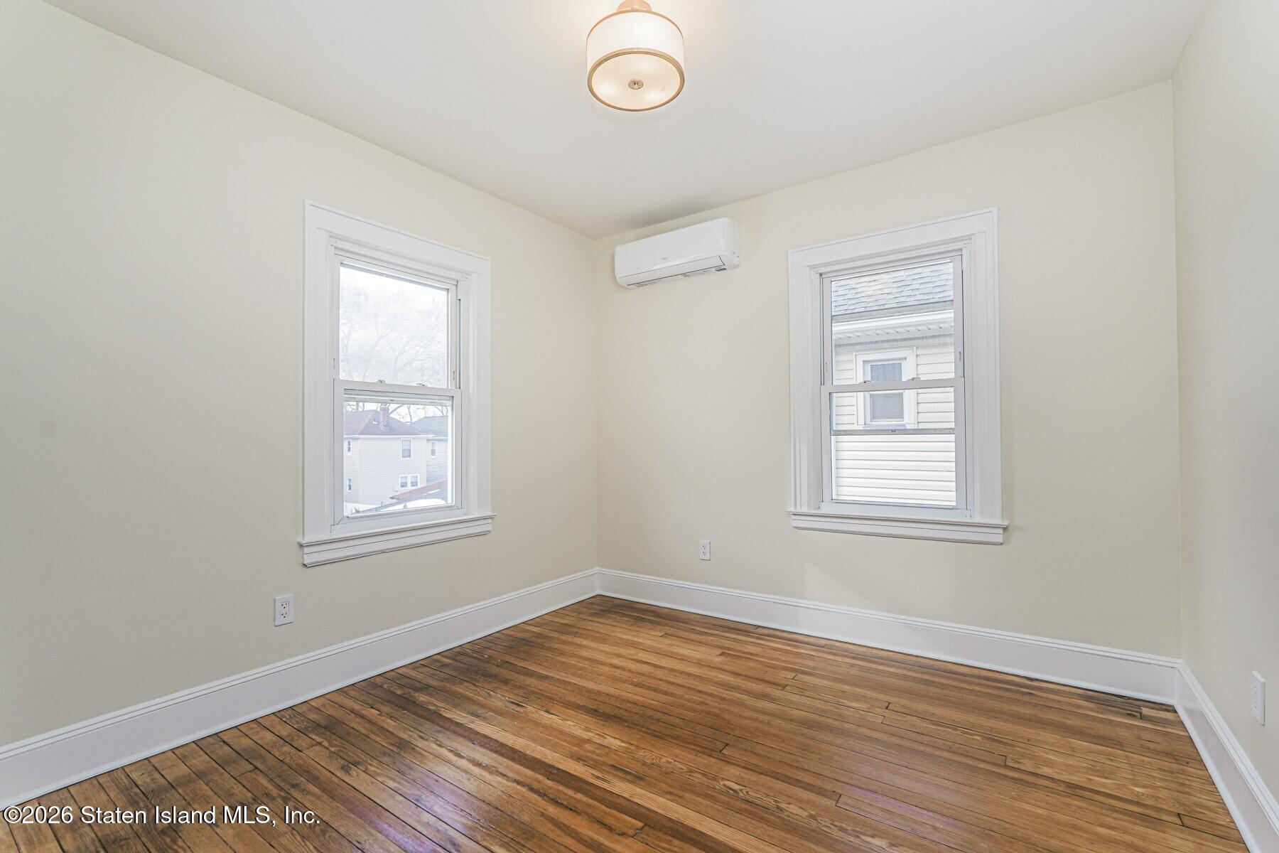 332 Willowbrook Road Staten Island, NY 10314 - Photo 13 of 17 an empty room with wooden floor and windows