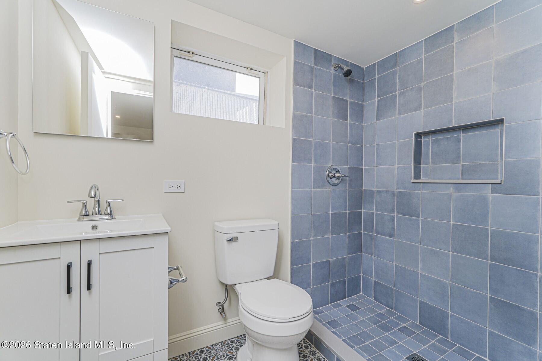 332 Willowbrook Road Staten Island, NY 10314 - Photo 17 of 17 a bathroom with a sink a toilet and a mirror