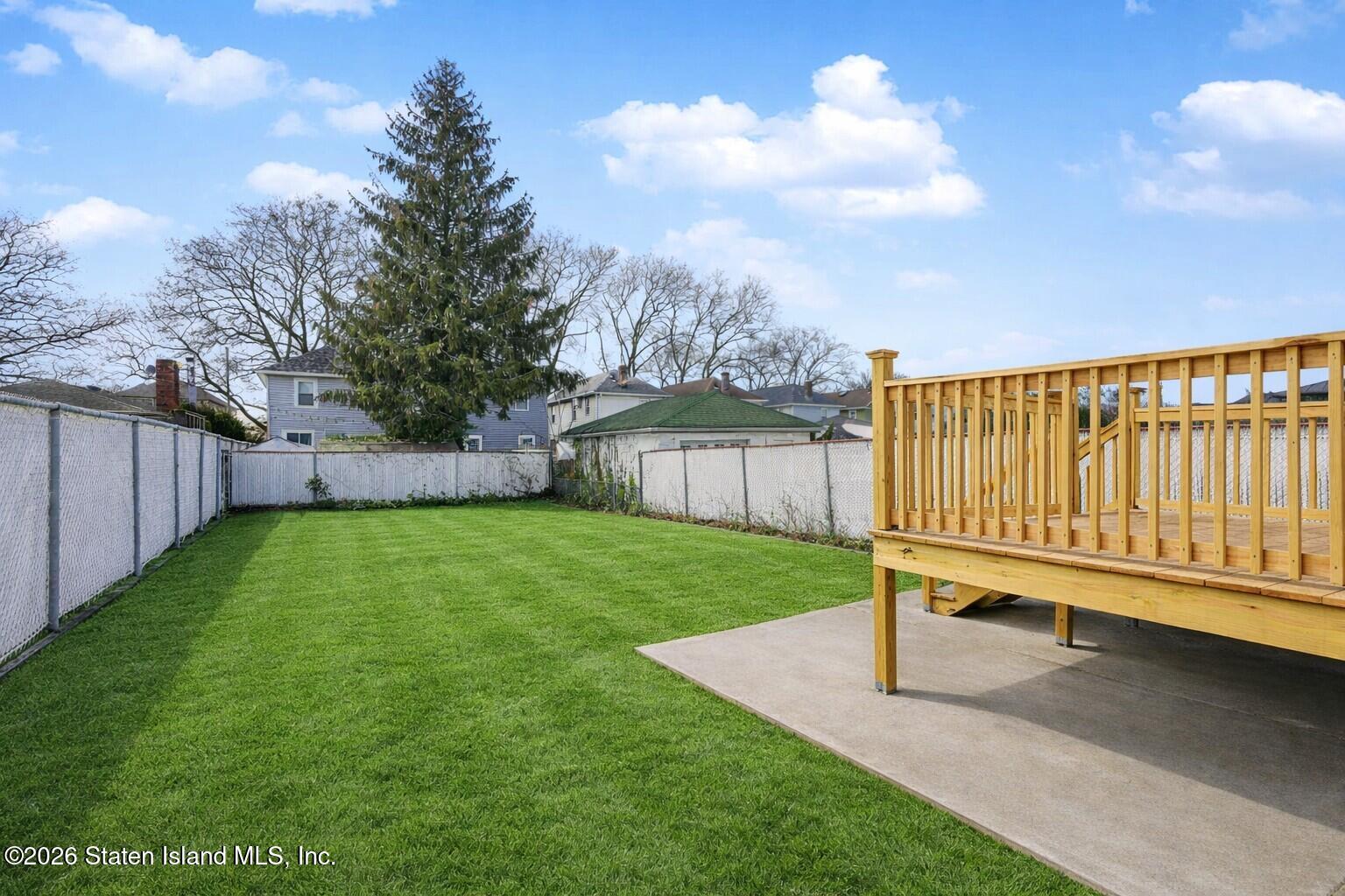 332 Willowbrook Road Staten Island, NY 10314 - Photo 3 of 17 a view of a back yard with a bench and wooden fence