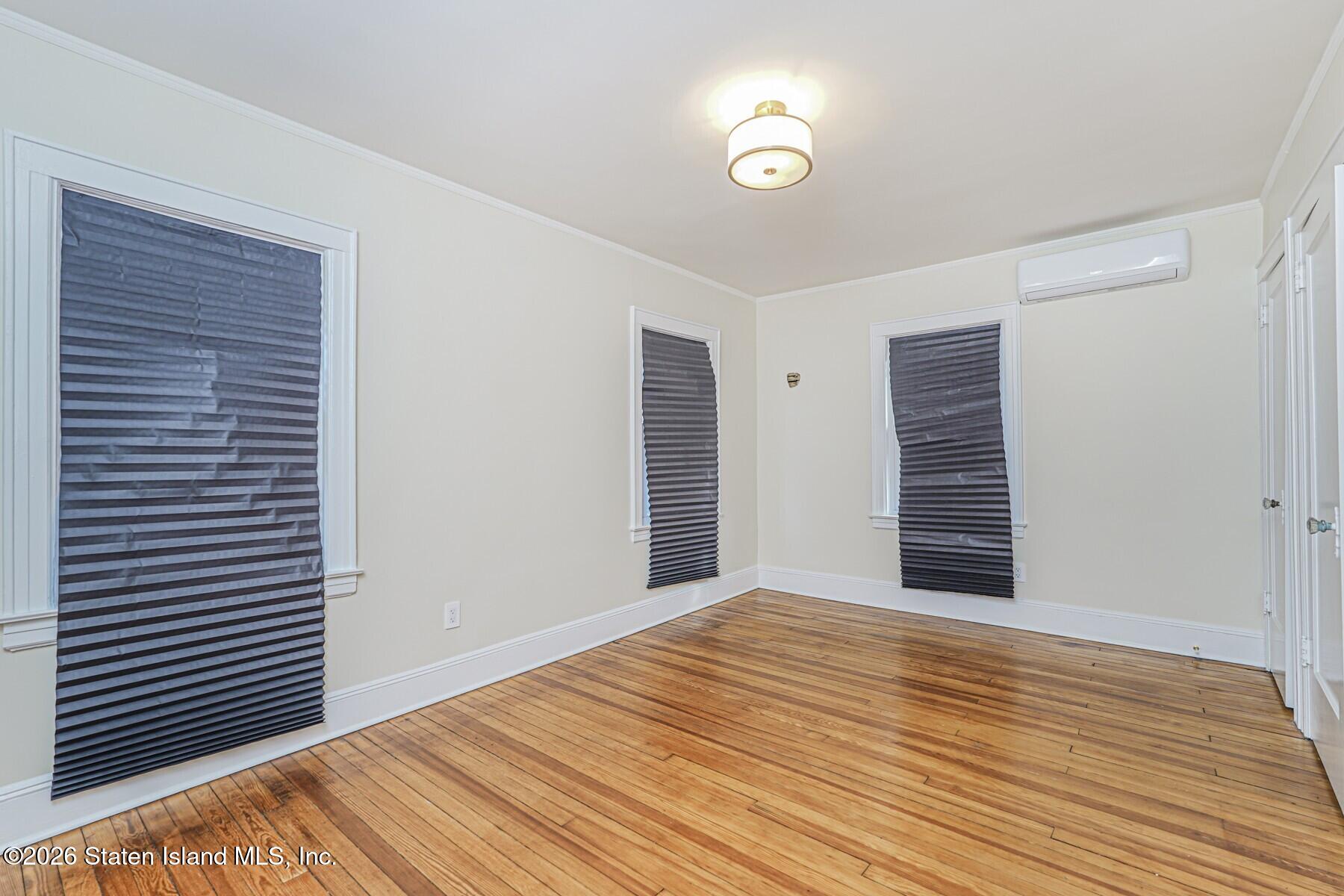 332 Willowbrook Road Staten Island, NY 10314 - Photo 10 of 17 a view of an empty room with wooden floor and a window