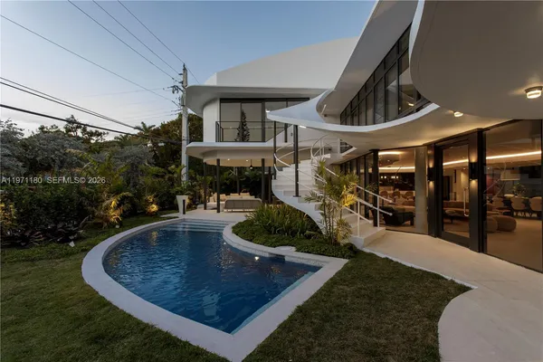a view of a house with backyard swimming pool and sitting area
