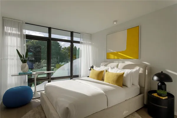 a bedroom with a bed and large window