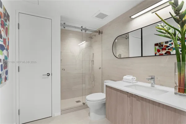a bathroom with a granite countertop sink toilet and shower
