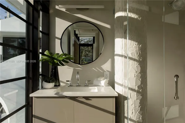 a bathroom with a granite countertop sink a mirror and a shower