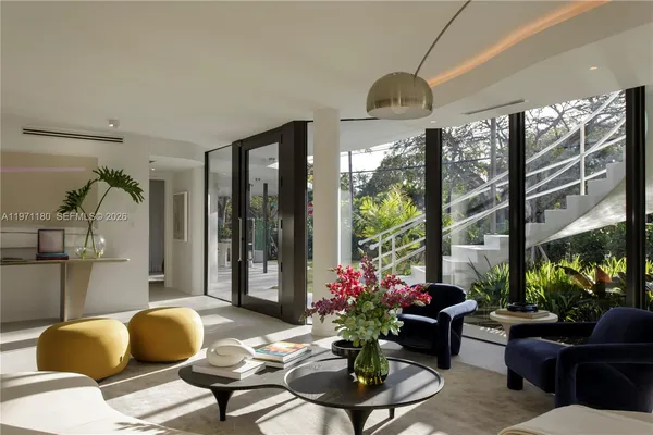 a living room with furniture potted plant and a large window