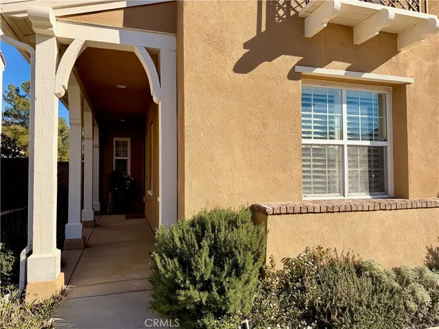 a view of a room with wooden floor a ceiling fan and windows