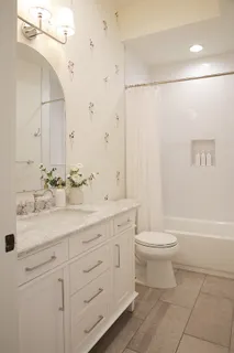 a bathroom with a double vanity sink a toilet and a bathtub