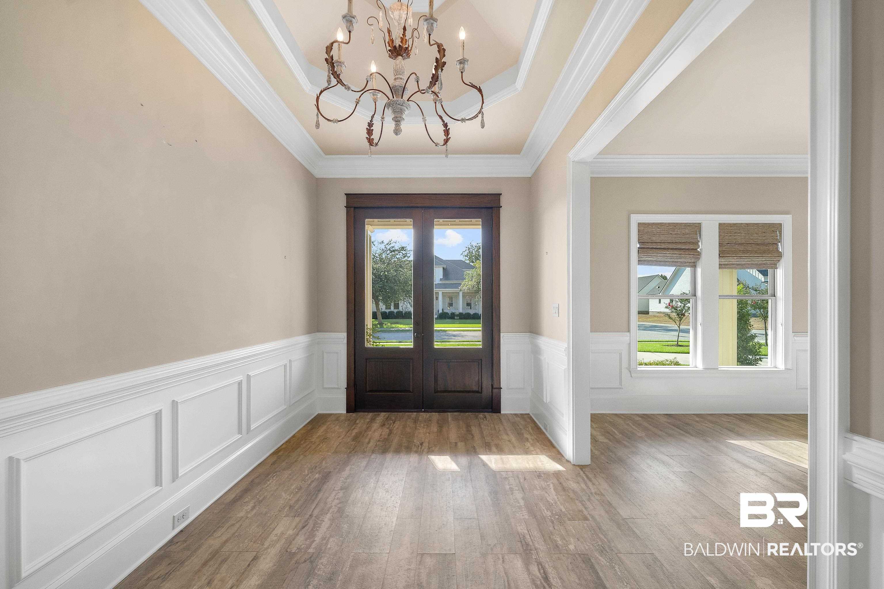 17663 Burwick Loop Fairhope, AL 36532 - Photo 6 of 41 Foyer entrance featuring a notable chandelier, a raised ceiling, crown molding, and hardwood / wood-style flooring
