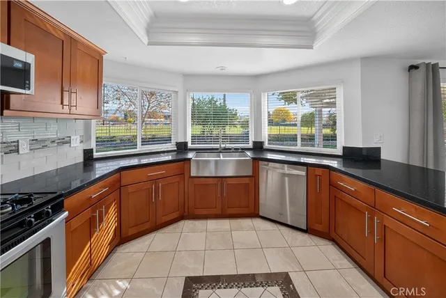 a large kitchen with stainless steel appliances granite countertop a stove a sink and a microwave