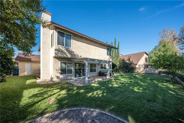 a view of a house with backyard and sitting area