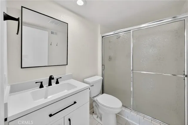 a bathroom with a sink a mirror a toilet and shower