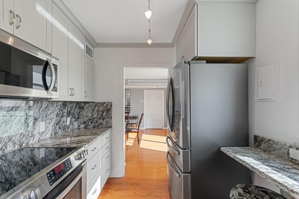136 Lakeshore Drive, Unit PH10 North Palm Beach, FL 33408 - Photo 6 of 38 a kitchen with stainless steel appliances granite countertop a sink and a stove