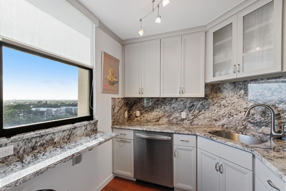 136 Lakeshore Drive, Unit PH10 North Palm Beach, FL 33408 - Photo 7 of 38 a kitchen with stainless steel appliances white cabinets and a granite counter tops