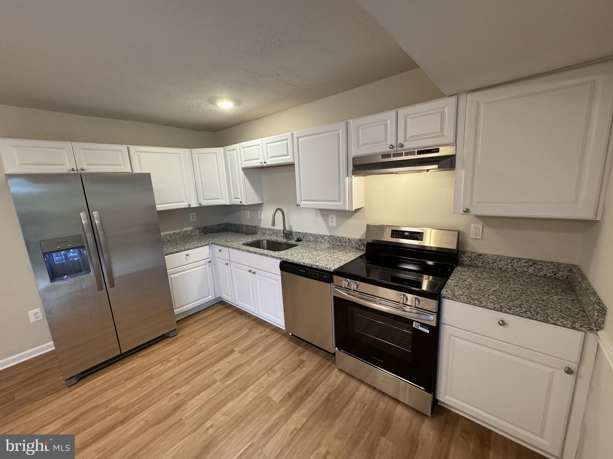 5140 Redbud Road Fredericksburg, VA 22407 - Photo 9 of 22 a kitchen with granite countertop white cabinets and white appliances