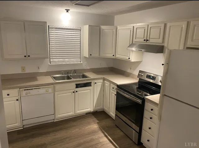 a kitchen with granite countertop white cabinets and appliances