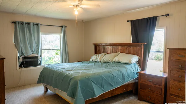 a bedroom with a bed mirror and window