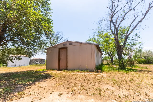 a view of a house with a yard and tree