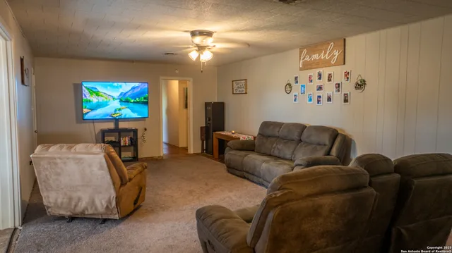 a living room with furniture a chandelier and a flat screen tv