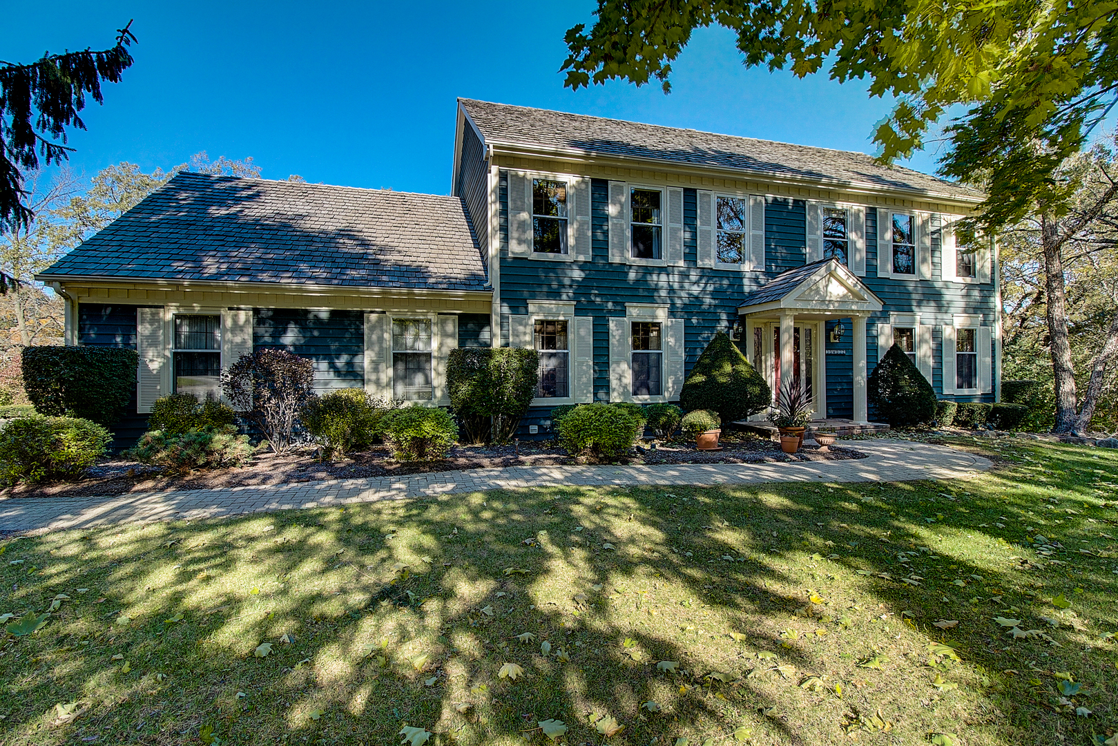 a front view of a house with yard patio and swimming pool