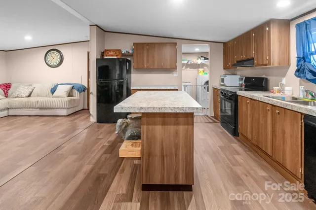 a kitchen with stainless steel appliances granite countertop wooden cabinets a sink and a stove