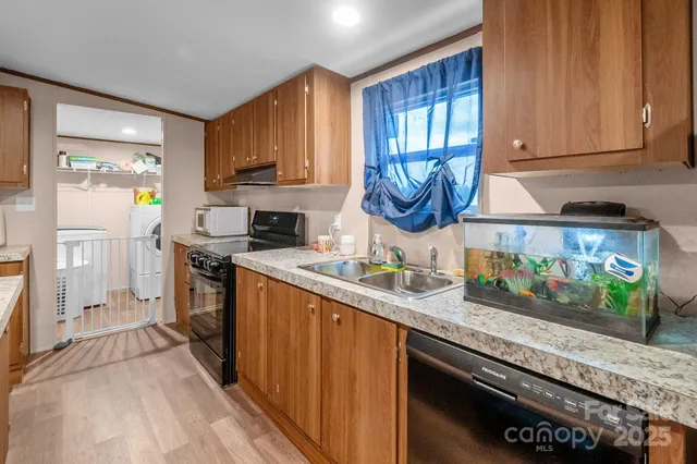 a kitchen with stainless steel appliances granite countertop a stove a sink and a microwave