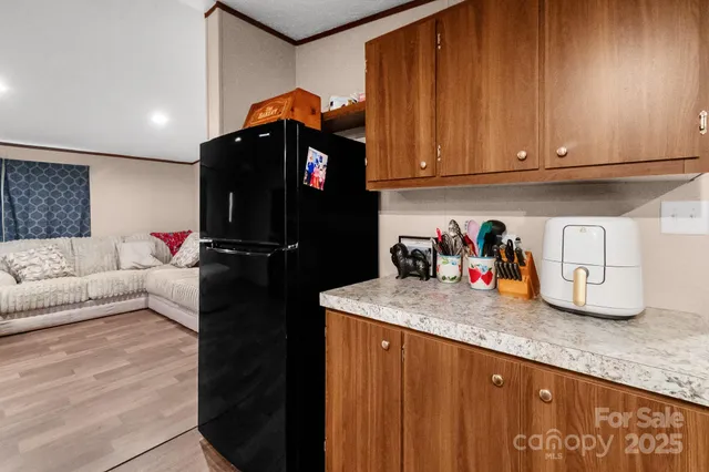 a kitchen with granite countertop a refrigerator and a stove top oven