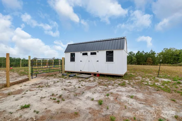 a view of a dry yard with wooden fence