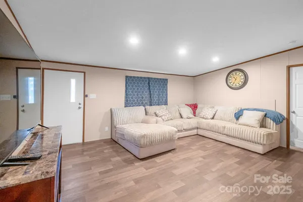 a living room with furniture wooden floor and a large window