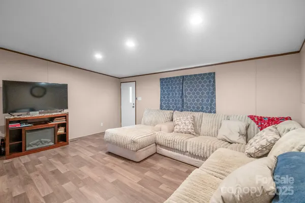 a spacious bedroom with a bed and a flat screen tv