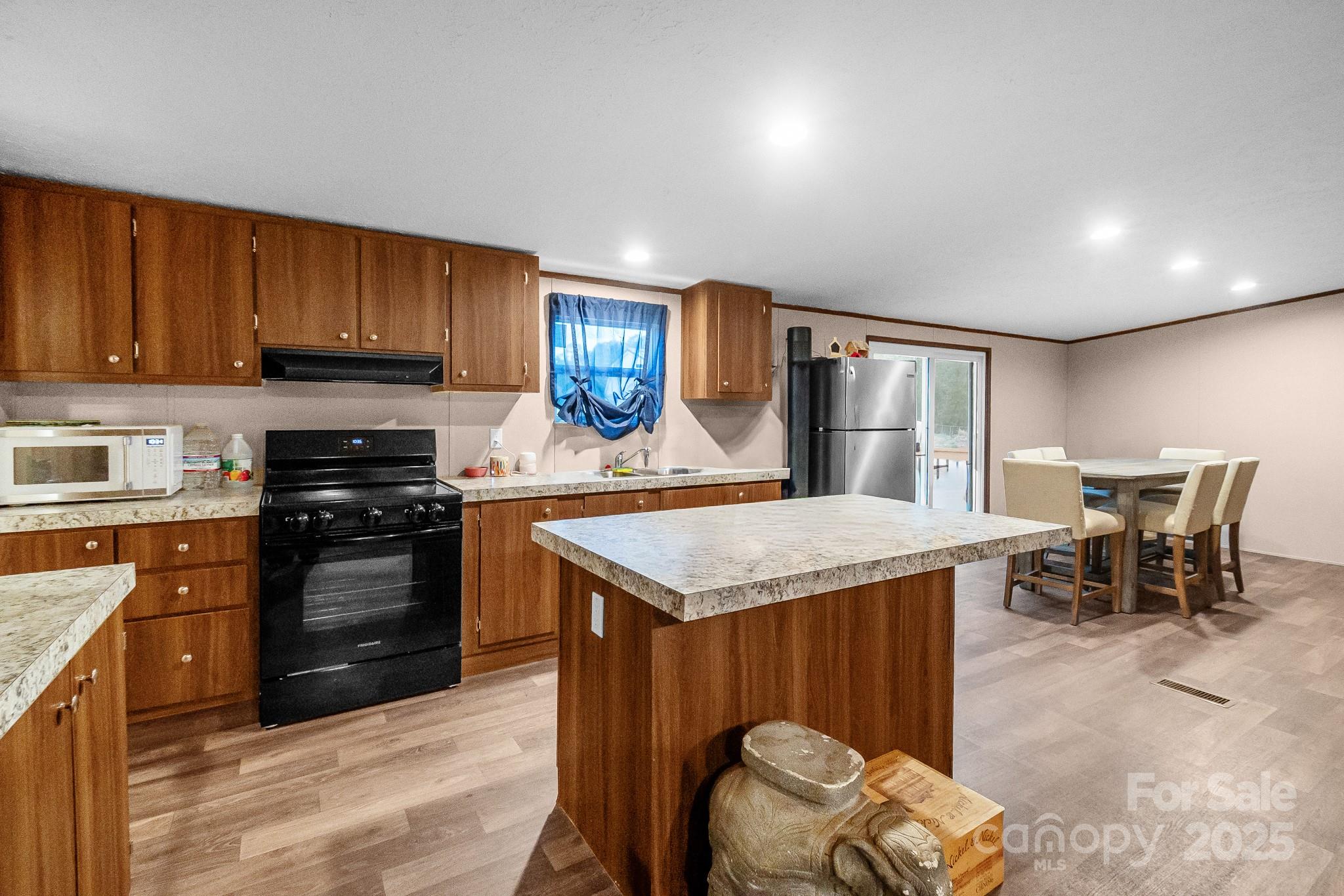 5263 Raleys Mill Road Bethune, SC 29009 - Photo 10 of 37 a kitchen with stainless steel appliances granite countertop a stove top oven a sink dishwasher and a refrigerator with wooden cabinets