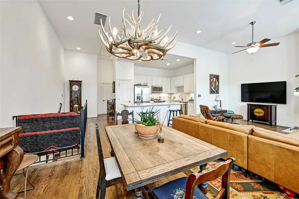 a view of a dining room with furniture a chandelier and wooden floor
