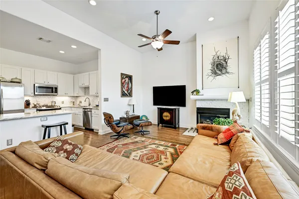 a open kitchen with stainless steel appliances granite countertop a stove refrigerator and a view of living room