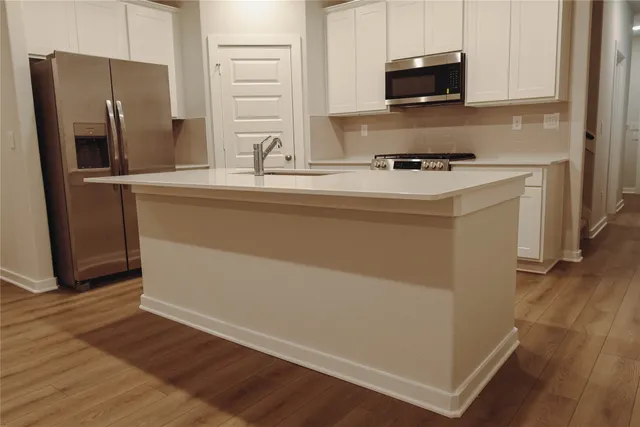 a kitchen with stainless steel appliances a refrigerator microwave and sink