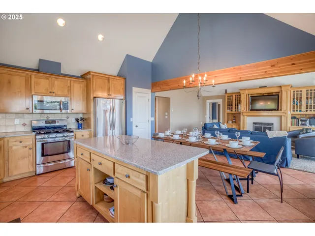 a open kitchen with stainless steel appliances kitchen island granite countertop a stove a sink a dining table and chairs