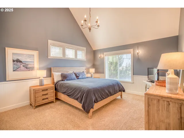 a spacious bedroom with a bed window and dresser
